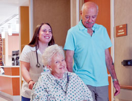 A nurse rolling a patient's wheelchair through the hospital hallways. Links to Donor-Advised Funds