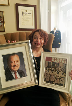 Judi Betts sitting, holding up two frames